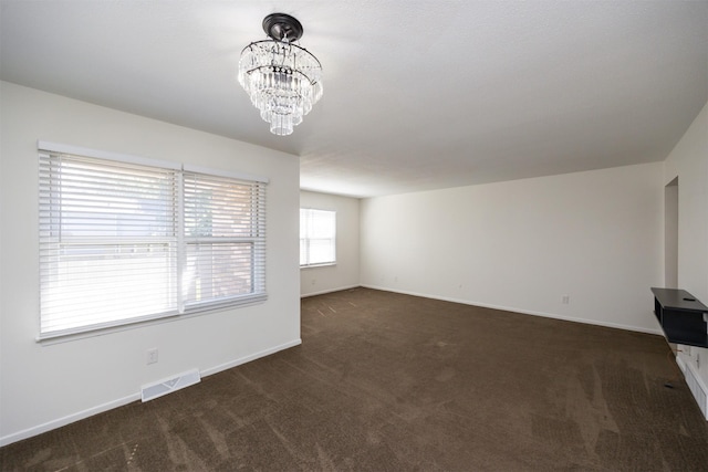 1667 NW 93rd Ct, Clive, IA 50325 - unfurnished living room featuring dark carpet, a chandelier, and baseboards