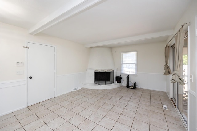 1667 NW 93rd Ct, Clive, IA 50325 - unfurnished living room featuring a large fireplace, beamed ceiling, wainscoting, and light tile patterned flooring