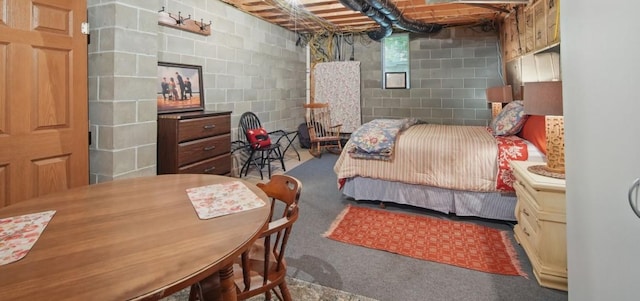 carpeted bedroom with concrete block wall