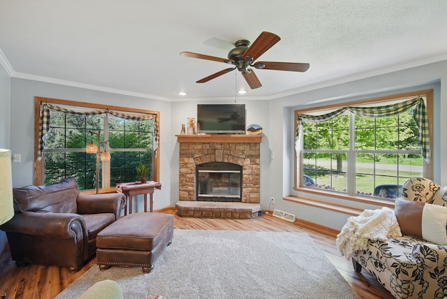 living room with plenty of natural light, ornamental molding, baseboards, ceiling fan, and wood finished floors