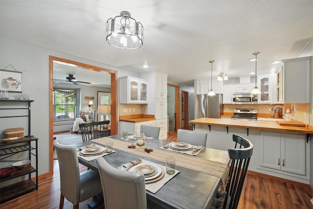 dining area featuring dark wood-style flooring, a chandelier, a ceiling fan, and recessed lighting