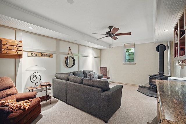 living room with carpet flooring, ceiling fan, a wood stove, and recessed lighting