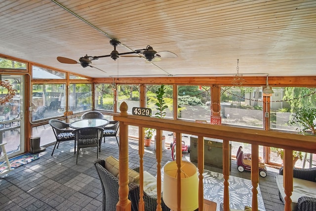sunroom featuring brick patterned floors, wooden ceiling, and a ceiling fan