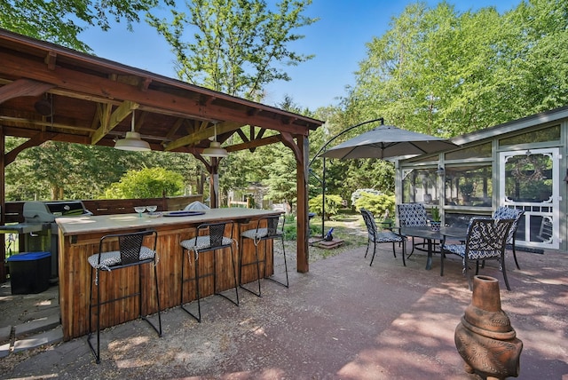 view of patio with a grill and a sunroom