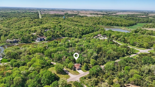 view of property location featuring a large body of water and a heavily wooded area