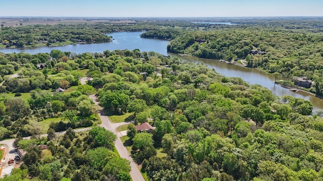 drone / aerial view of a large body of water and a heavily wooded area