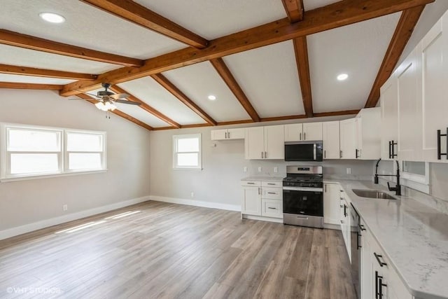 kitchen featuring appliances with stainless steel finishes, a sink, ceiling fan, light stone countertops, and recessed lighting