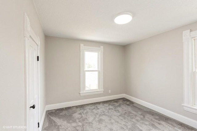 empty room featuring carpet floors and baseboards