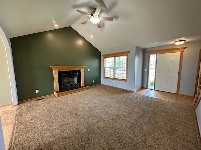 322 N 15th Ave, Winterset, IA 50273 - unfurnished living room featuring ceiling fan, a tile fireplace, carpet floors, baseboards, and arched walkways