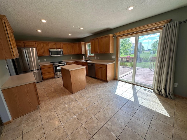 322 N 15th Ave, Winterset, IA 50273 - kitchen with appliances with stainless steel finishes, a sink, a textured ceiling, light countertops, and recessed lighting