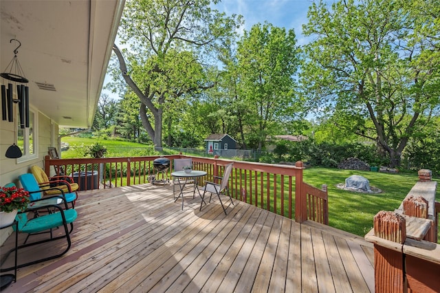 wooden terrace with view of scattered trees and outdoor dining space