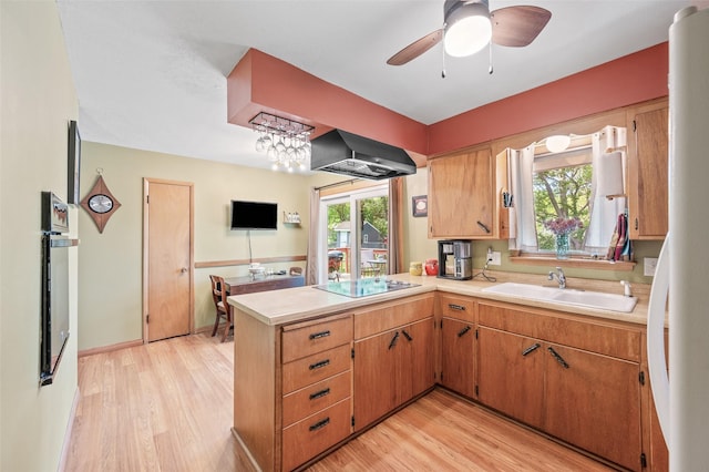 kitchen featuring extractor fan, black appliances, light countertops, and a sink