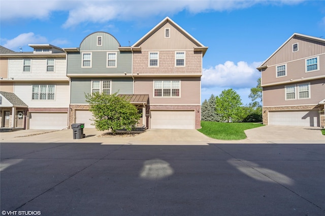 view of front of property featuring an attached garage, concrete driveway, and brick siding