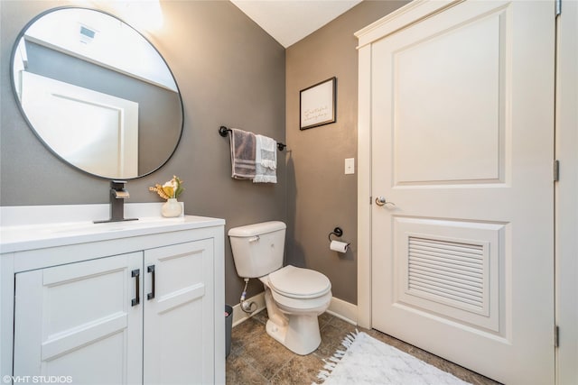 bathroom featuring toilet, vanity, baseboards, and tile patterned floors
