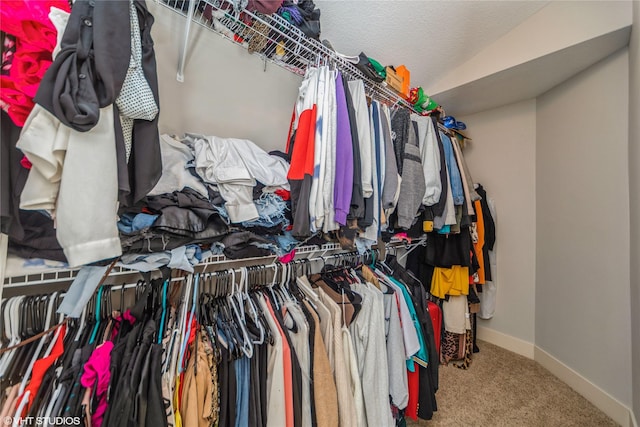 walk in closet featuring carpet floors and vaulted ceiling