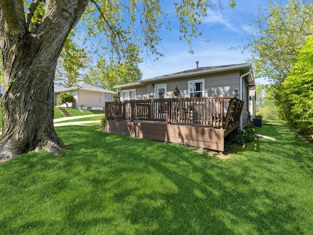 rear view of property featuring a wooden deck, a yard, and central air condition unit