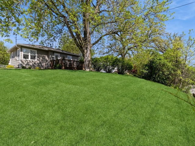 view of green lawn with a wooden deck