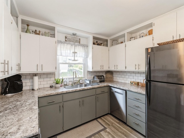 kitchen featuring stainless steel appliances, tasteful backsplash, light wood finished floors, and light countertops