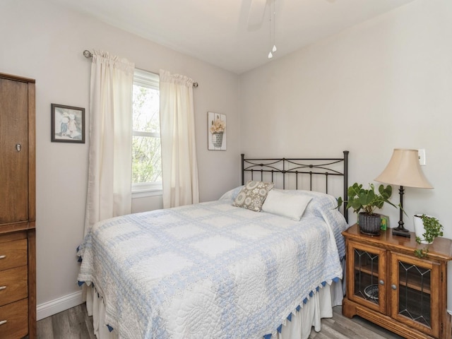 bedroom with wood finished floors, baseboards, and ceiling fan