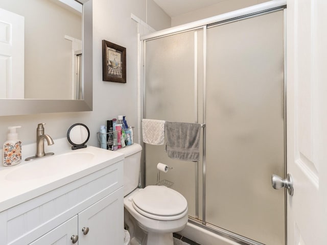 full bath with a stall shower, toilet, and vanity
