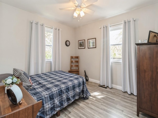 bedroom featuring light wood-style floors, baseboards, and a ceiling fan