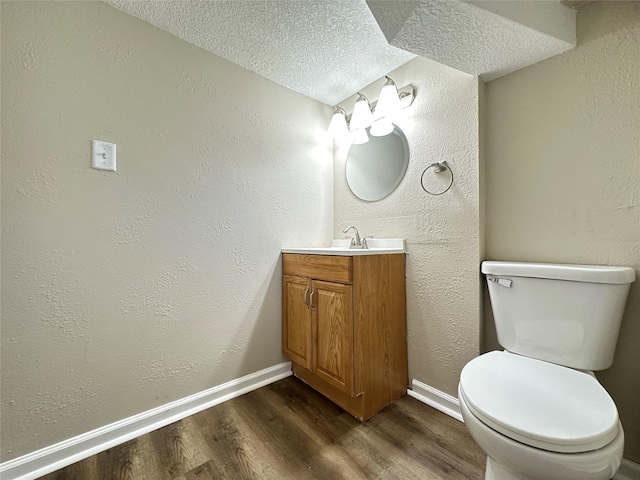 3429 54th St, Des Moines, IA 50310 - half bathroom with wood finished floors, toilet, baseboards, vanity, and a textured ceiling