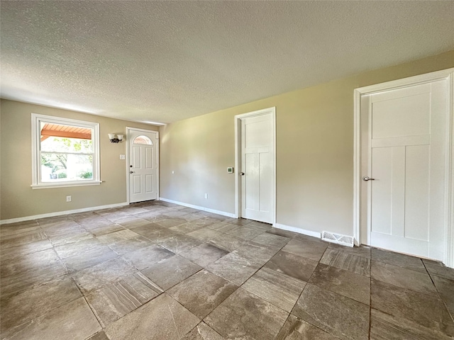 3429 54th St, Des Moines, IA 50310 - spare room with baseboards, a textured ceiling, and stone finish floors