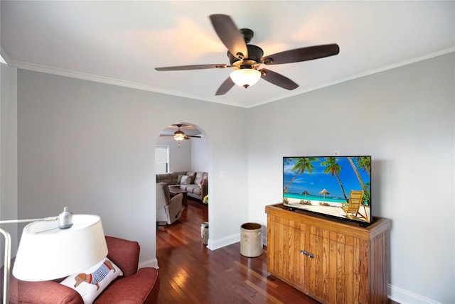 living room featuring ceiling fan, wood finished floors, ornamental molding, baseboards, and arched walkways
