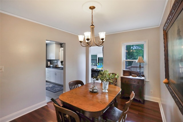 dining area featuring dark wood-style flooring, a chandelier, baseboards, and crown molding