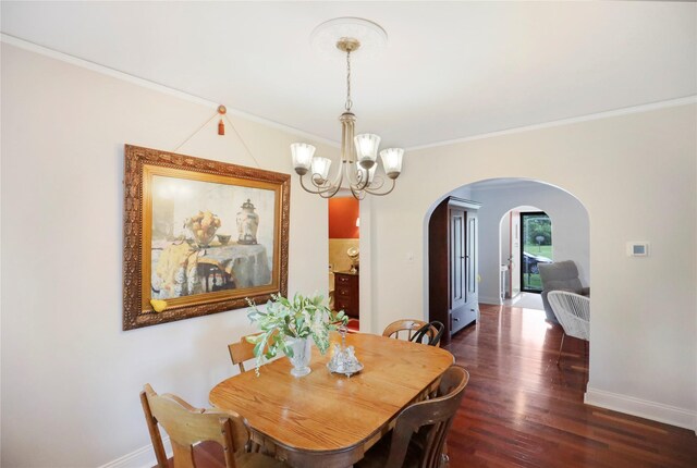 4027 Fagen Dr, Des Moines, IA 50310 - dining room featuring arched walkways, a chandelier, baseboards, crown molding, and wood finished floors