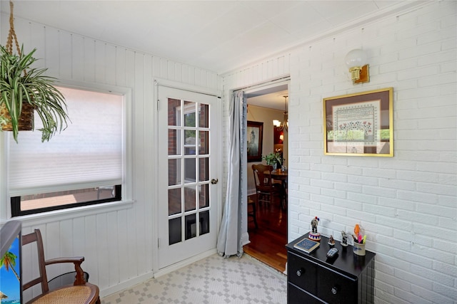doorway featuring wood finished floors and brick wall