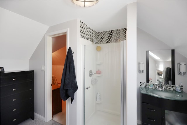 bathroom featuring a shower stall, vanity, and vaulted ceiling