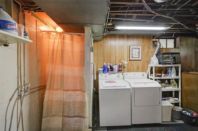 laundry room featuring separate washer and dryer and wooden walls