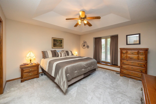 10760 Elmcrest Dr, Clive, IA 50325 - bedroom featuring a raised ceiling, light colored carpet, baseboards, and ceiling fan