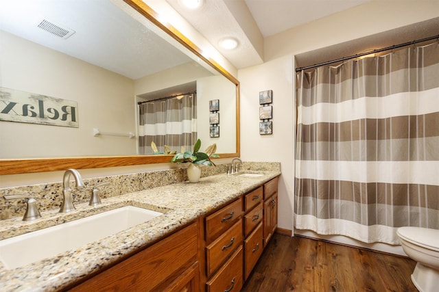 10760 Elmcrest Dr, Clive, IA 50325 - full bath featuring toilet, wood finished floors, double vanity, and a shower with shower curtain