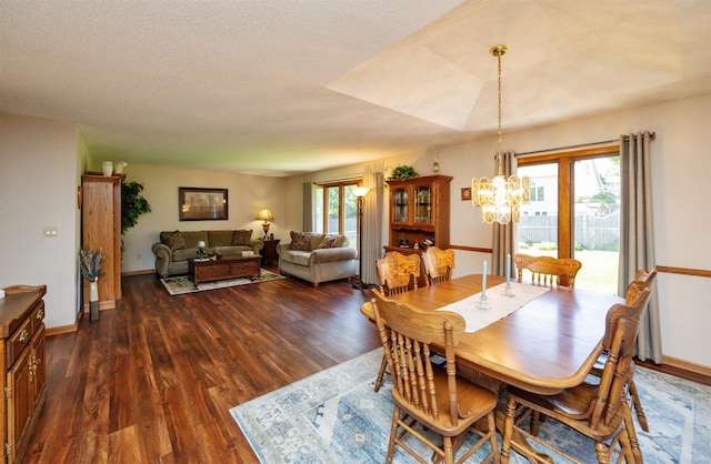 10760 Elmcrest Dr, Clive, IA 50325 - dining space with a chandelier, dark wood-type flooring, and baseboards
