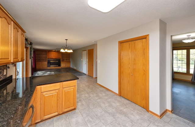 5433 NW 89th St, Johnston, IA 50131 - kitchen featuring a peninsula, a chandelier, baseboards, open floor plan, and a textured ceiling
