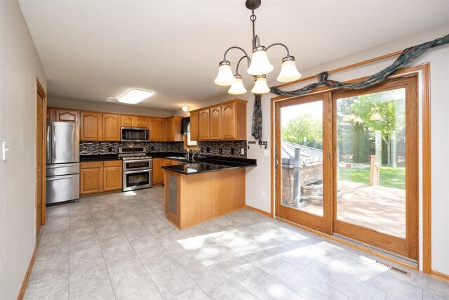 5433 NW 89th St, Johnston, IA 50131 - kitchen featuring appliances with stainless steel finishes, a sink, a peninsula, baseboards, and decorative backsplash