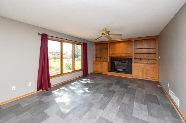 5433 NW 89th St, Johnston, IA 50131 - unfurnished living room featuring a glass covered fireplace, baseboards, and a ceiling fan