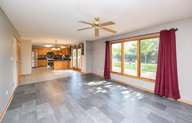 5433 NW 89th St, Johnston, IA 50131 - unfurnished living room featuring a chandelier, baseboards, and a ceiling fan
