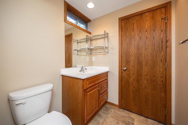 5433 NW 89th St, Johnston, IA 50131 - bathroom featuring toilet, vanity, stone finish floors, and baseboards