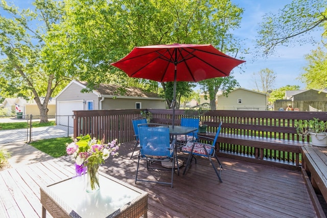604 NE 8th St, Grimes, IA 50111 - wooden terrace with outdoor dining area, an outbuilding, and fence
