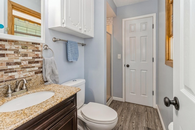 604 NE 8th St, Grimes, IA 50111 - full bath featuring a stall shower, toilet, decorative backsplash, and wood finished floors