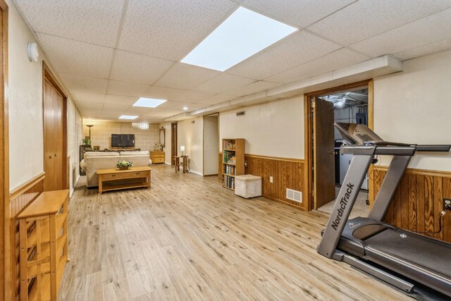 604 NE 8th St, Grimes, IA 50111 - exercise area featuring a paneled ceiling, light wood-type flooring, a wainscoted wall, and wood walls