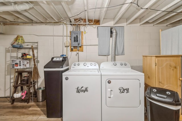 604 NE 8th St, Grimes, IA 50111 - clothes washing area with independent washer and dryer, concrete block wall, electric panel, and wood finished floors
