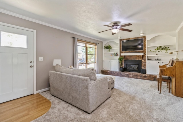 604 NE 8th St, Grimes, IA 50111 - living room featuring a brick fireplace, ceiling fan, crown molding, built in features, and wood finished floors