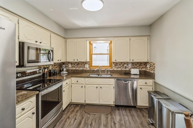 604 NE 8th St, Grimes, IA 50111 - kitchen featuring stainless steel appliances, a sink, decorative backsplash, and dark wood-style flooring