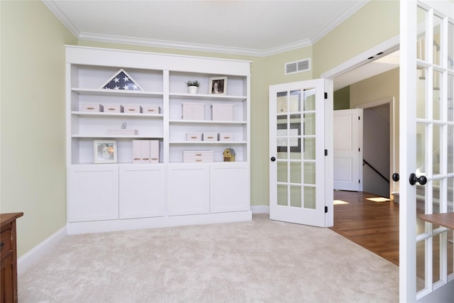 carpeted empty room featuring ornamental molding, baseboards, and french doors
