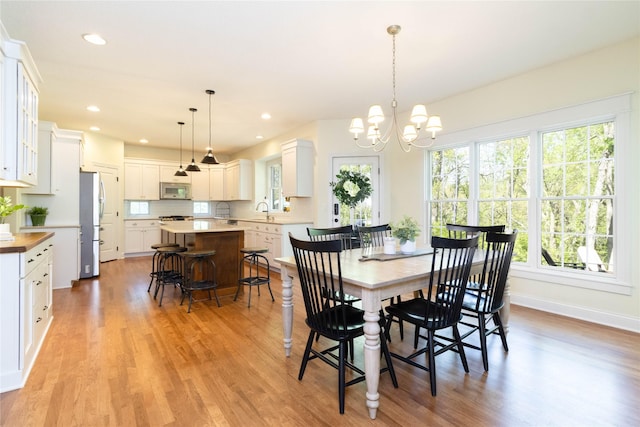dining room featuring light wood-style floors, a chandelier, recessed lighting, and baseboards