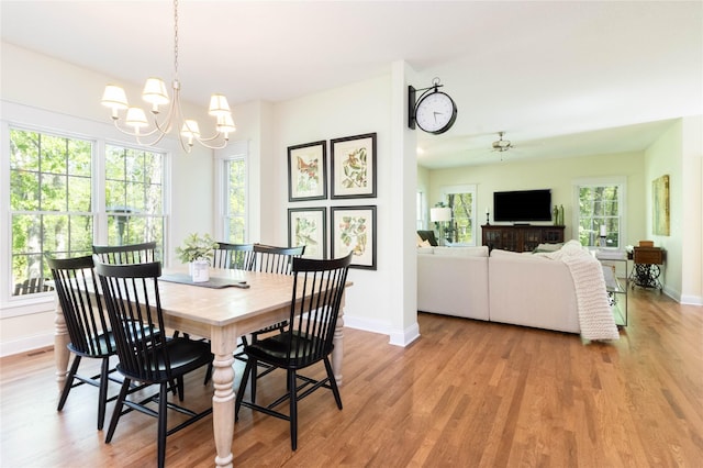 dining room featuring baseboards, a chandelier, and light wood-style floors